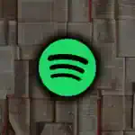 Logotipo do Spotify sobre uma pilha de livros abertos, simbolizando a integração de livros físicos com a plataforma de streaming.