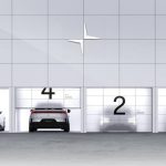 Estacionamento com quatro portas de carregamento numeradas de 2 a 5, com carros elétricos Polestar em frente, simbolizando a ofensiva elétrica da marca até 2028.